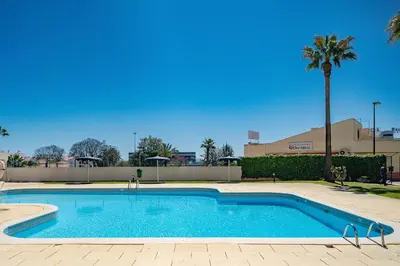 a swimming pool with a palm tree next to a building at LovelyStay - Bela Vista 3BDR Duplex Penthouse with Pool in Albufeira