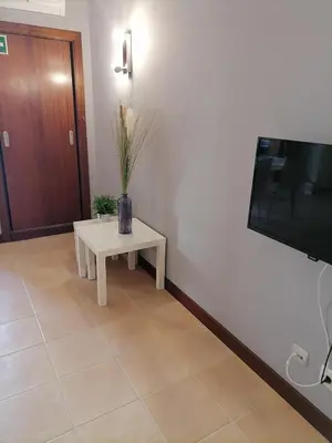 a living room with a table and a tv at Aparto Golf in Guia