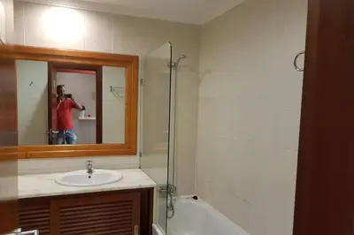 a man taking a picture of a bathroom with a mirror at Aparto Golf in Guia
