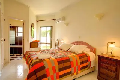 a bedroom with a bed with a colorful blanket at Villa Aldeia by Villa Plus in Albufeira