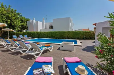 a group of chairs and a swimming pool with a bunch ofitures at Villa Altis by Villa Plus in Albufeira