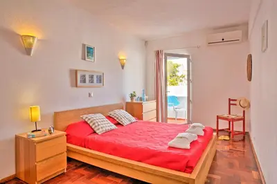 a bedroom with a red bed with a red blanket at Villa Altis Park by Villa Plus in Albufeira