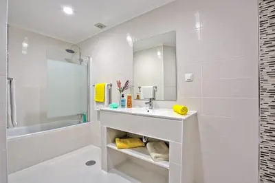 a white bathroom with a sink and a mirror at Villa Altis Park by Villa Plus in Albufeira