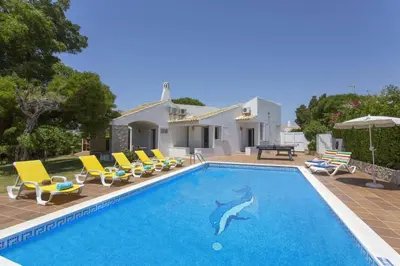 a swimming pool with chairs and a dolphin in a house at Villa Elo by Villa Plus in Albufeira