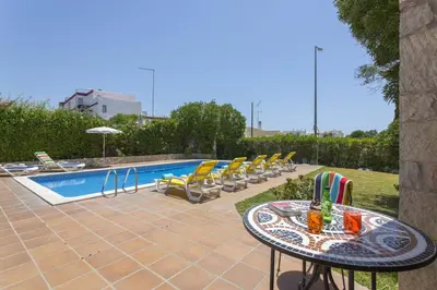 a patio with a table and chairs next to a pool at Villa Elo by Villa Plus in Albufeira