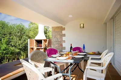 a dining room with a table and chairs and a fireplace at Villa Elo by Villa Plus in Albufeira