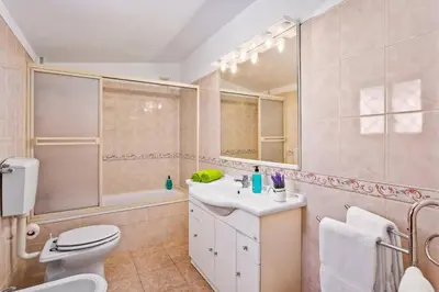 a bathroom with a toilet and a sink and a shower at Villa Emilio Pequena by Villa Plus in Albufeira