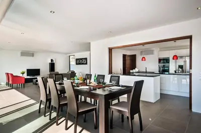 a dining room and kitchen with a table and chairs at Villa Eve by Villa Plus in Olhos de Água