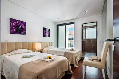 a hotel room with two beds and a window at Villa Eve by Villa Plus in Olhos de Água