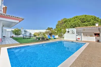 a living room with a white couch and a table at Villa Rosa by Villa Plus in Olhos de Água