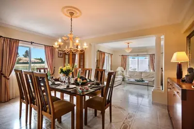 a dining room with a table and chairs at Villa Rosa by Villa Plus in Olhos de Água