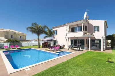 a villa with a swimming pool in front of a house at Villa Soni by Villa Plus in Olhos de Água
