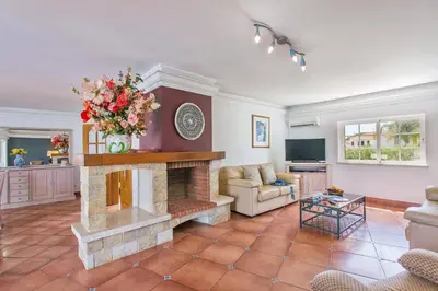 a living room with a fireplace and a couch at Villa Soni by Villa Plus in Olhos de Água