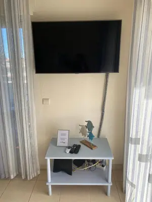 a tv on a wall with a table with a tv on it at House Amendoeiras , Vila moura in Vilamoura