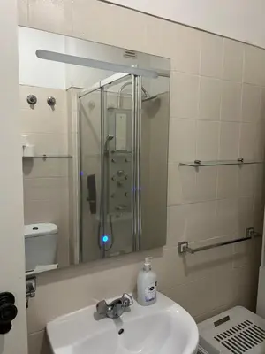 a bathroom with a sink and a shower and a mirror at House Amendoeiras , Vila moura in Vilamoura