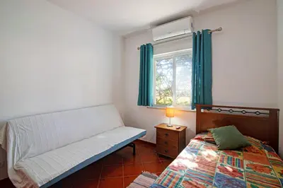 a small bedroom with a bed and a window at Villa Isabel in Loulé