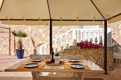 a table under an umbrella on a patio at Villa Isabel in Loulé