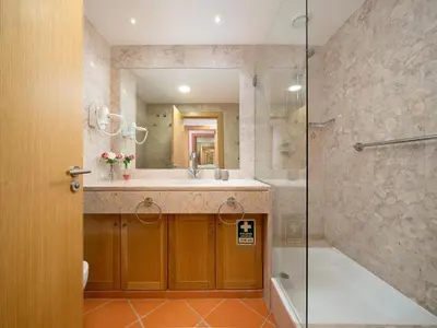 a bathroom with a shower and a sink and a tub at AL - Apartamento Vila Sol F5 AD in Vilamoura