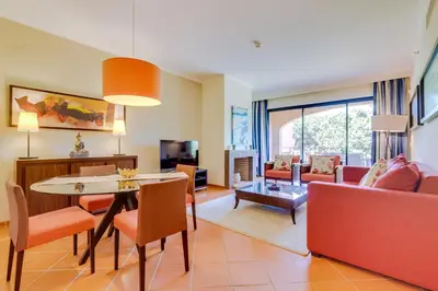 a living room with a couch and a table and chairs at AL - Apartamento Vila Sol F5 AD in Vilamoura