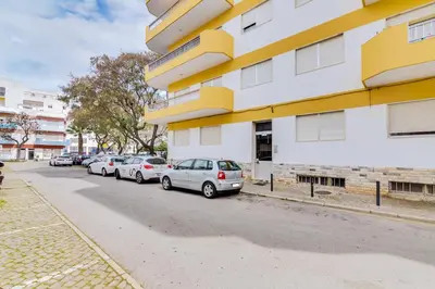 a row of cars parked next to a building at Quarteira 2Br - near the beach at Homesbyfc in Quarteira
