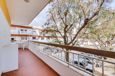 a balcony with a view of a tree at Quarteira 2Br - near the beach at Homesbyfc in Quarteira