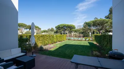 a garden with a couch and a lawn at Central Vilamoura Townhouse in Quarteira