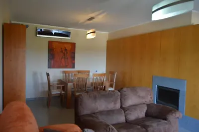a living room with a couch and a table and chairs at Apartamento frente ao mar com piscina de água salgada in Quarteira