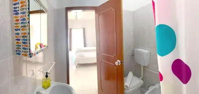 a bathroom with a white toilet and a sink at The Central Guesthouse in Faro