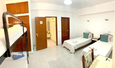 a room with two bunk beds and a bathroom at The Central Guesthouse in Faro