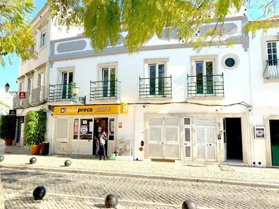 a person standing in front of a white building at The Central Guesthouse in Faro