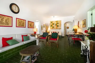 a living room with a couch and chairs and a clock at WHome | Balaia 3-Bed Family Holiday Villa in Olhos de Água