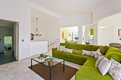 a bedroom with a bed with red pillows and a chair at Villa Ninho da Aguia by Villa Plus in Albufeira