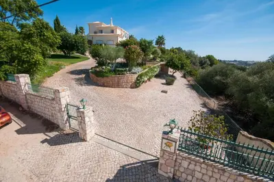 a fence in front of a house with a garden at Villa Nenufa by Villa Plus in Albufeira