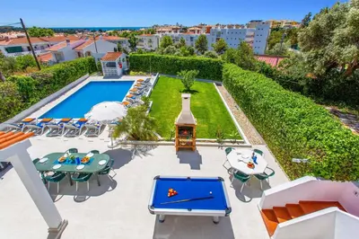 a swimming pool with lounge chairs next to a building at Villa Animado by Villa Plus in Albufeira