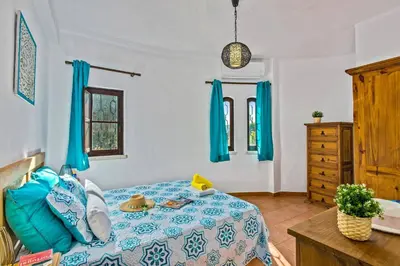 a bedroom with a bed and a dresser with blue curtains at Villa Casa do Laguinho by Villa Plus in Albufeira