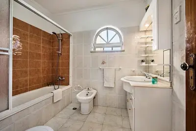 a bathroom with a sink and a toilet and a bath tub at Villa Cabrita, Superb location, large villa, walk to restaurants, supermarkets beach in Guia