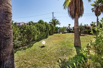 a yard with palm trees and a white object in the grass at Villa Cabrita, Superb location, large villa, walk to restaurants, supermarkets beach in Guia