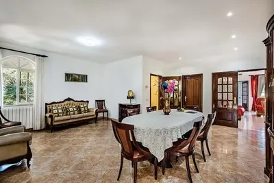 a dining room with a table and chairs and a couch at Villa Cabrita, Superb location, large villa, walk to restaurants, supermarkets beach in Guia