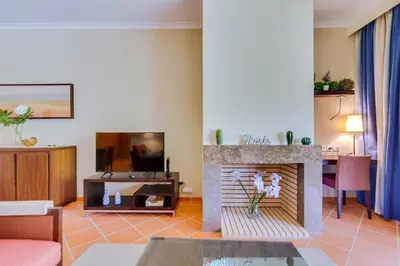a living room with a fireplace and a tv at AL - Apartamento Vila Sol F5 AB in Vilamoura