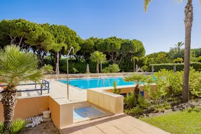 a swimming pool in a yard with trees at AL - Apartamento Vila Sol F5 AB in Vilamoura
