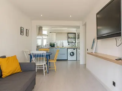 a living room with a couch and a table and a kitchen at Cosy beach apartment in Albufeira centre in Albufeira