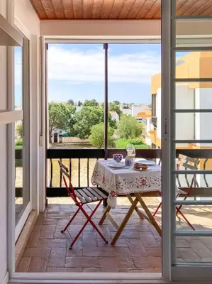 a table and chairs on a balcony with a view at Cosy beach apartment in Albufeira centre in Albufeira