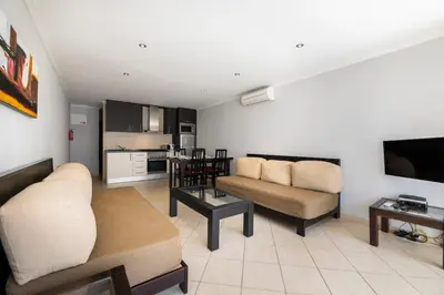 an apartment with a swimming pool in front of some buildings at ☼ Pé do Lago 1 Bedroom Apartment with Pool in Quarteira