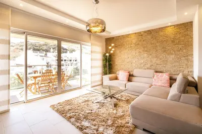 a living room with a couch and a brick wall at ALBUFEIRA (OLD TOWN) VERASOL AA - THE LUXURY STAY in Albufeira