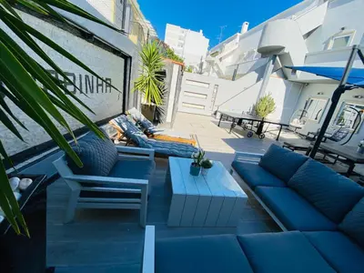a patio with a blue couch and chairs and a table at AL Barbinha in Faro
