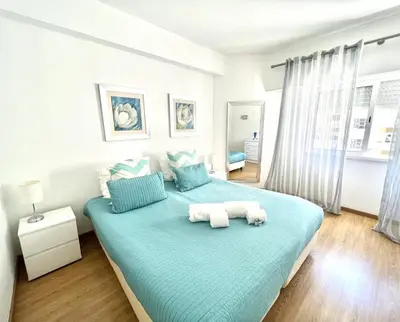 a bedroom with a large bed with two towels at Torre 20 - Near the beach - Quarteira in Quarteira
