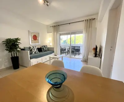 a kitchen and living room with a table and chairs at Torre 20 - Near the beach - Quarteira in Quarteira