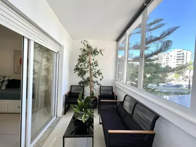 a living room with a couch and two windows at Torre 20 - Near the beach - Quarteira in Quarteira