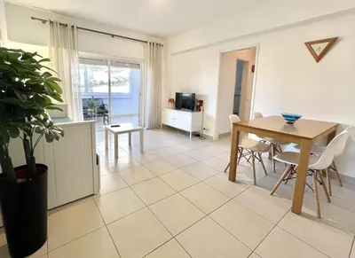 a living room with a table and chairs and a television at Torre 20 - Near the beach - Quarteira in Quarteira
