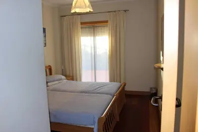 a small bedroom with a bed and a window at Charming 3-Bed Apartment in Albufeira in Albufeira
